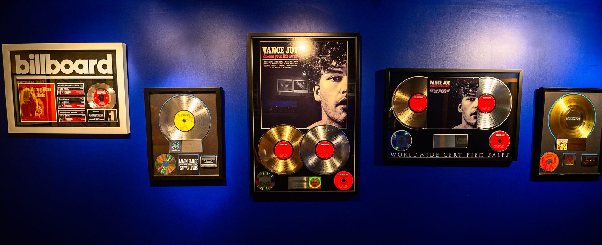 Gold and platinum plaques on the wall at Orbit Audio